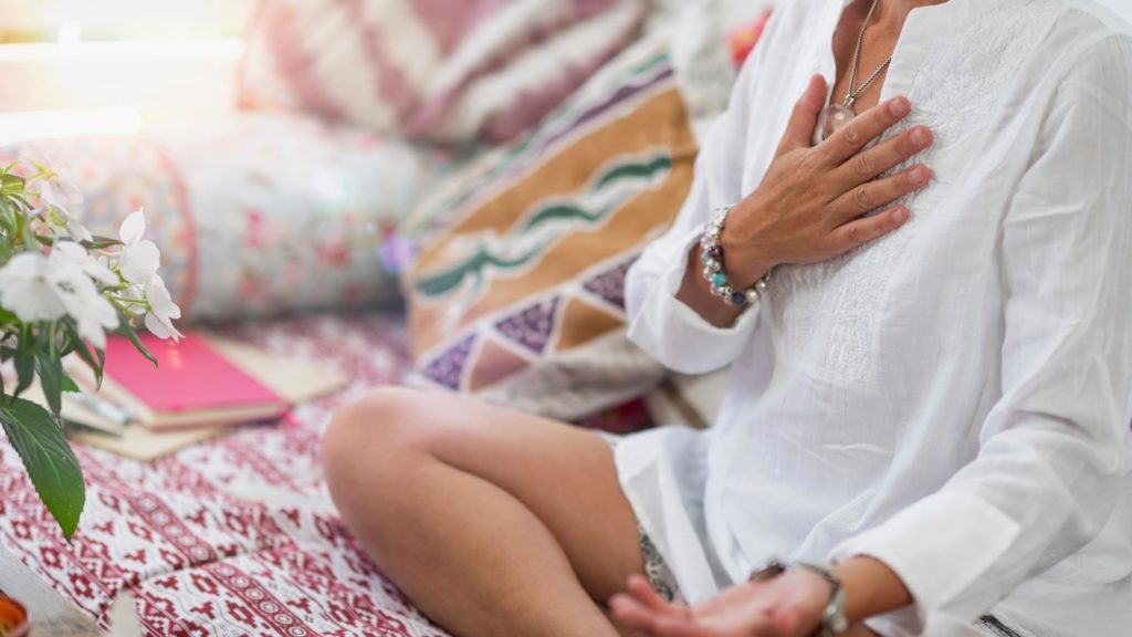 hand over heart in seated meditation